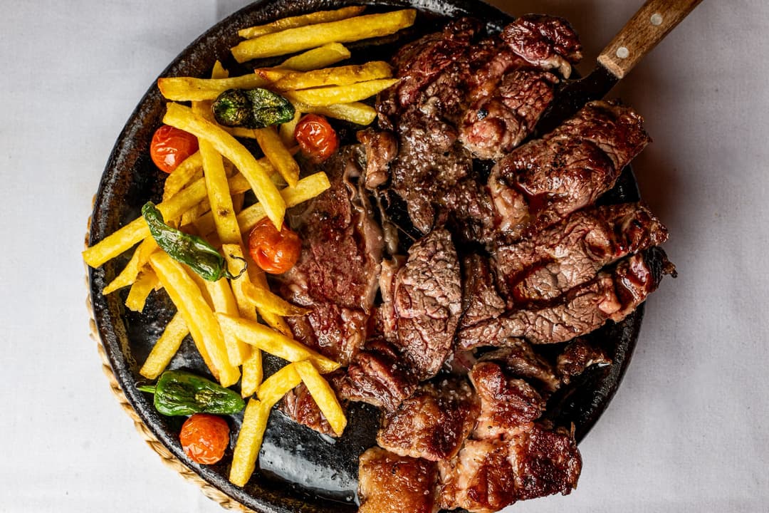 Entrecot de ternera acompañado de patatas fritas y pimientos de padrón.